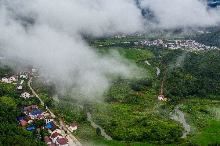 8月15日晨,平江縣甕江鎮晉坪村,雲霧繚繞,在建的平