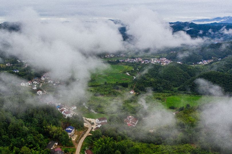 8月15日晨,平江縣甕江鎮晉坪村,雲霧繚繞,在建的平